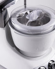 White ice cream maker with silver accents on a light gray background