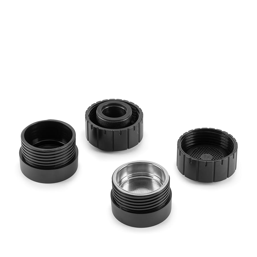 Four black and one silver cylindrical metal components on a white background