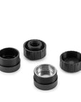 Four black and one silver cylindrical metal components on a white background