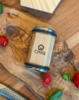 Cinq rolling knife sharpener on a wooden surface next to small tomatoes and a knife