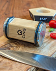 Cinq rolling Knife Sharper next to a knife and chopped tomatoes on a wooden surface