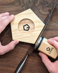 Someone demonstrating on how to use Cinq Knife Sharpening tool on a wooden surface