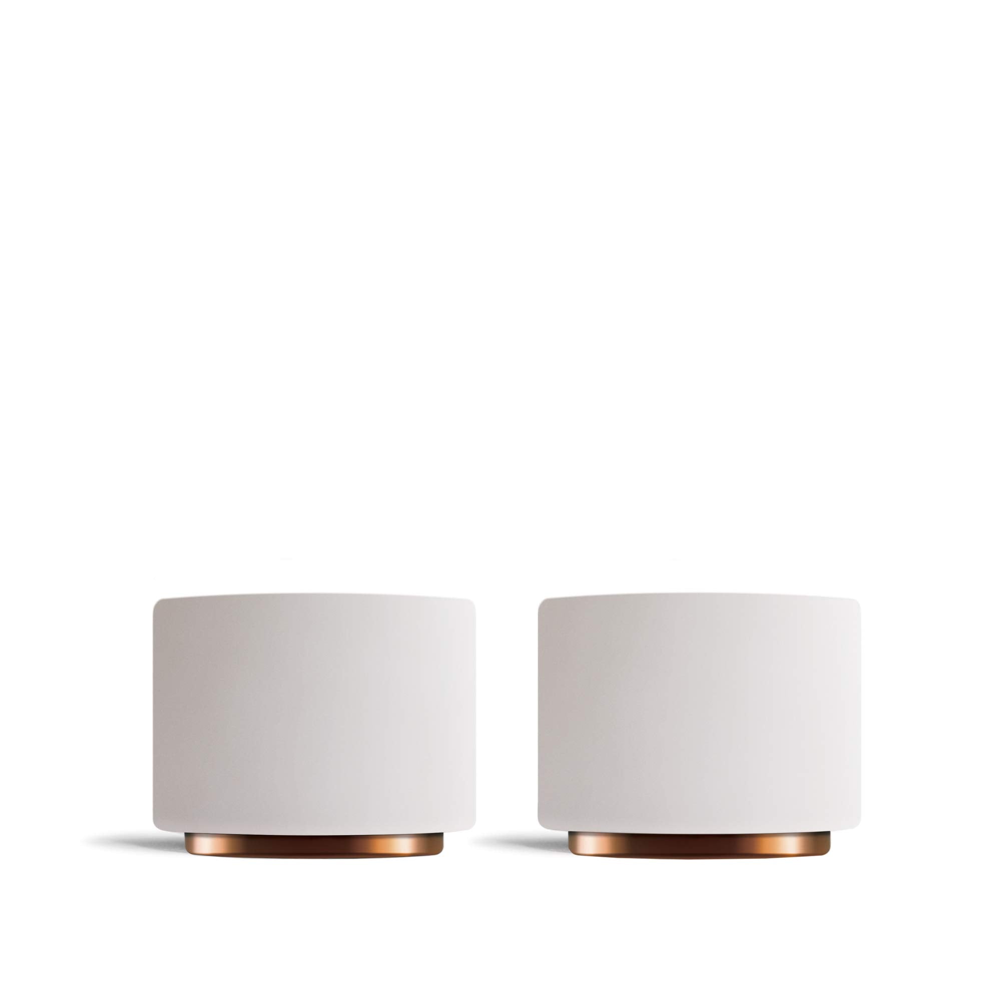 Two white cups with copper bases on a white background