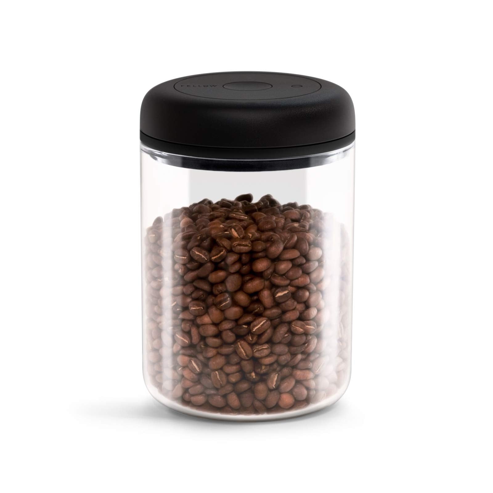 Clear jar with black lid filled with coffee beans on a white background