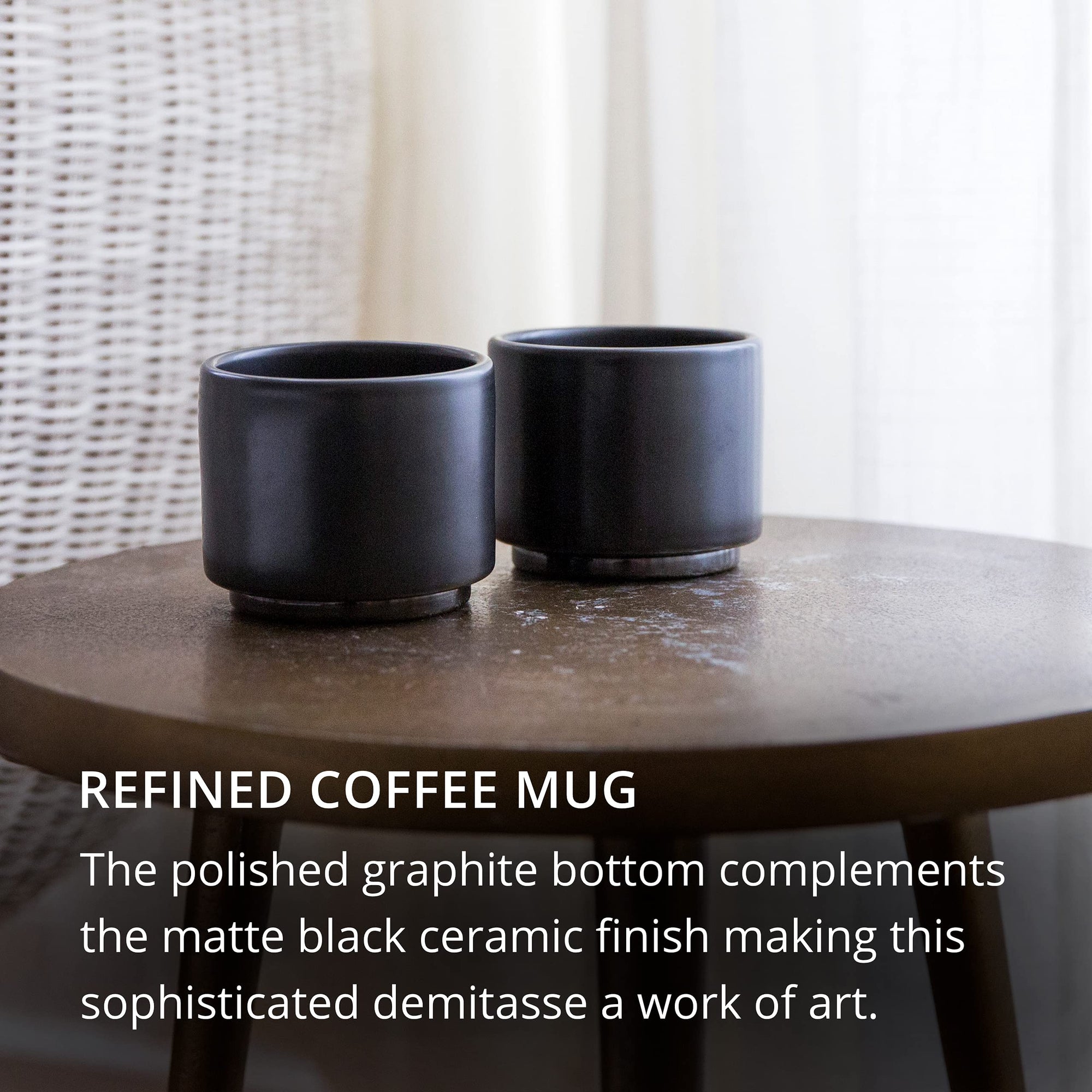 Two matte black ceramic coffee mugs on a wooden table with text describing the product.