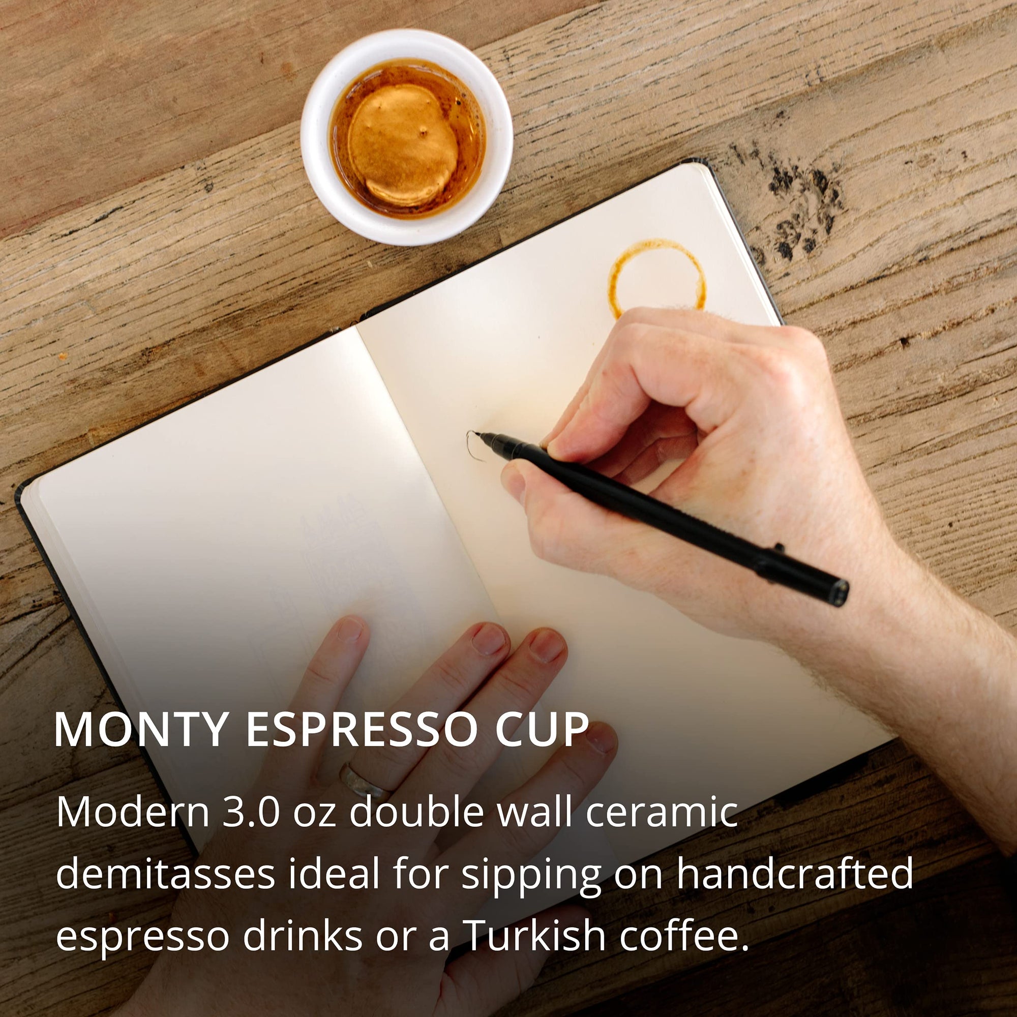 Hand writing in a notebook with a cup of coffee on a wooden surface, featuring the Monty Espresso Cup product description.