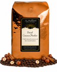 5 lb Decaf Cinnamon Hazelnut coffee beans bag with coffee beans, cinnamon sticks, and hazelnuts in front displayed on a white background
