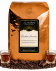 5 lb Coffee bag labeled 'Chocolate Amaretto' by J.L. Hufford with two shot glasses of amaretto, chocolate shavings, and coffee beans.