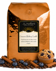 5 lb Cinnamon Blueberry Crumble coffee beans bag with coffee beans, blueberries, cinnamon sticks, and blueberry crumble muffin in front displayed on a white background