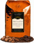 5 lb J.L. Hufford Praline Caramel Swirl Coffee with coffee beans, roasted pralines, caramel blocks, and dark chocolate bars in front displayed on a white background