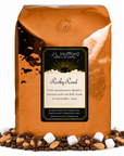 5 lb J.L. Hufford Rocky Road coffee bag with coffee beans, marshmallows, and peanuts covered in melted chocolate on a white background