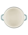 White inside of an enamel on steel traditional petite stockpot with hands on a white background