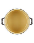 Dark cream inside of the enamel on steel traditional petite stockpot with handles on a white background