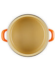 Dark cream inside of the enamel on steel traditional petite stockpot with handles on a white background