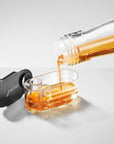 A close-up image of the JURA syrup attachment having syrup being poured into it on a white background