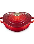 Cerise heart shaped 1.25 qt cocotte with handles and a light gold heart knob displayed on a white background