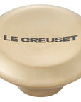 Light gold knob with 'Le Creuset' branding on a white background