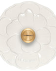 White ceramic dish with gold knob featuring 'Le Creuset' branding on a white background