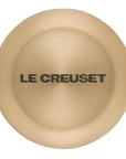Light gold knob with 'Le Creuset' branding on a white background
