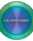 Le Creuset logo on a steel iridescent knob on a white background