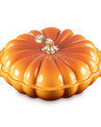 Persimmon cast iron signature pumpkin braiser with handles and gold knob on a white background