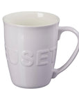 White ceramic mug with 'Huset' embossed on a white background