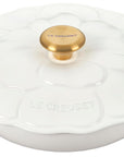 White enameled cast iron cookware with a gold knob on a white background