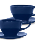 Set of two indigo 12 oz notneutral lino porcelain latte cup and saucer on a white background