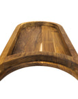 Bottom view of a teak chopping board with the raised platform with a cutout section for a plate on a white background