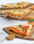 Pizza on Rico & Plato Napoletana 15 inch pizza serving board on a white counter