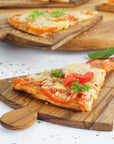Pizza on Rico & Plato Napoletana 15 inch pizza serving board on a white counter