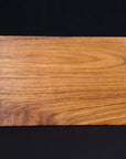 Top view of Rico & Plato wasabi teak serving platter displayed on a black background