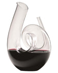 A clear, curly-shaped handmade decanter made of fine crystal, designed for wine aeration, with red wine inside
