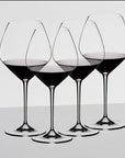 Four Riedel Pino Noir wine glass with red wine inside all on a white background