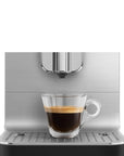 Espresso shot on a black, silver Smeg fully automatic coffee machine on a white background