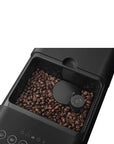 Top view of a black Smeg fully automatic coffee machine showing where the coffee beans are contained on a white background