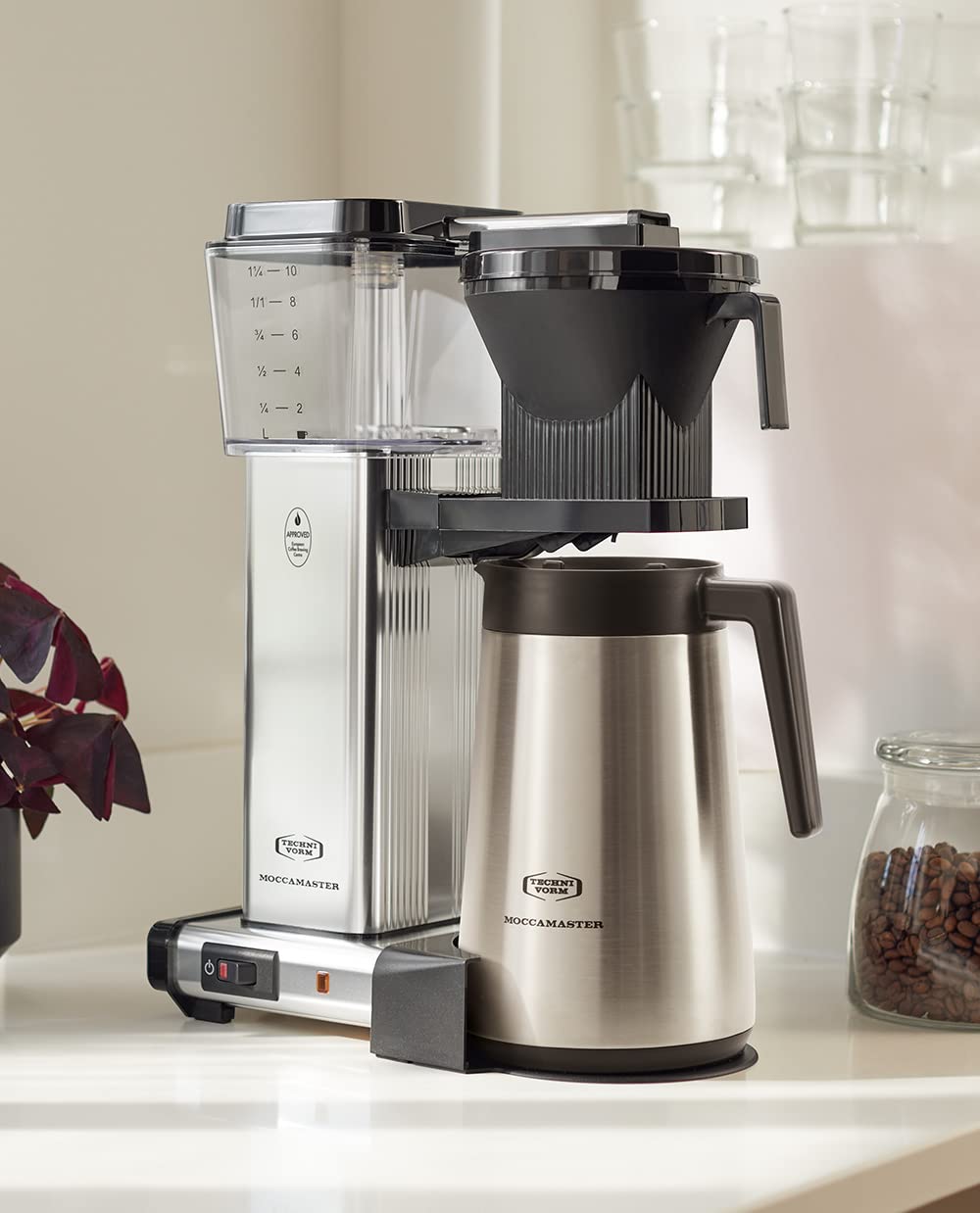 Silver coffee maker with thermal carafe on a kitchen counter.