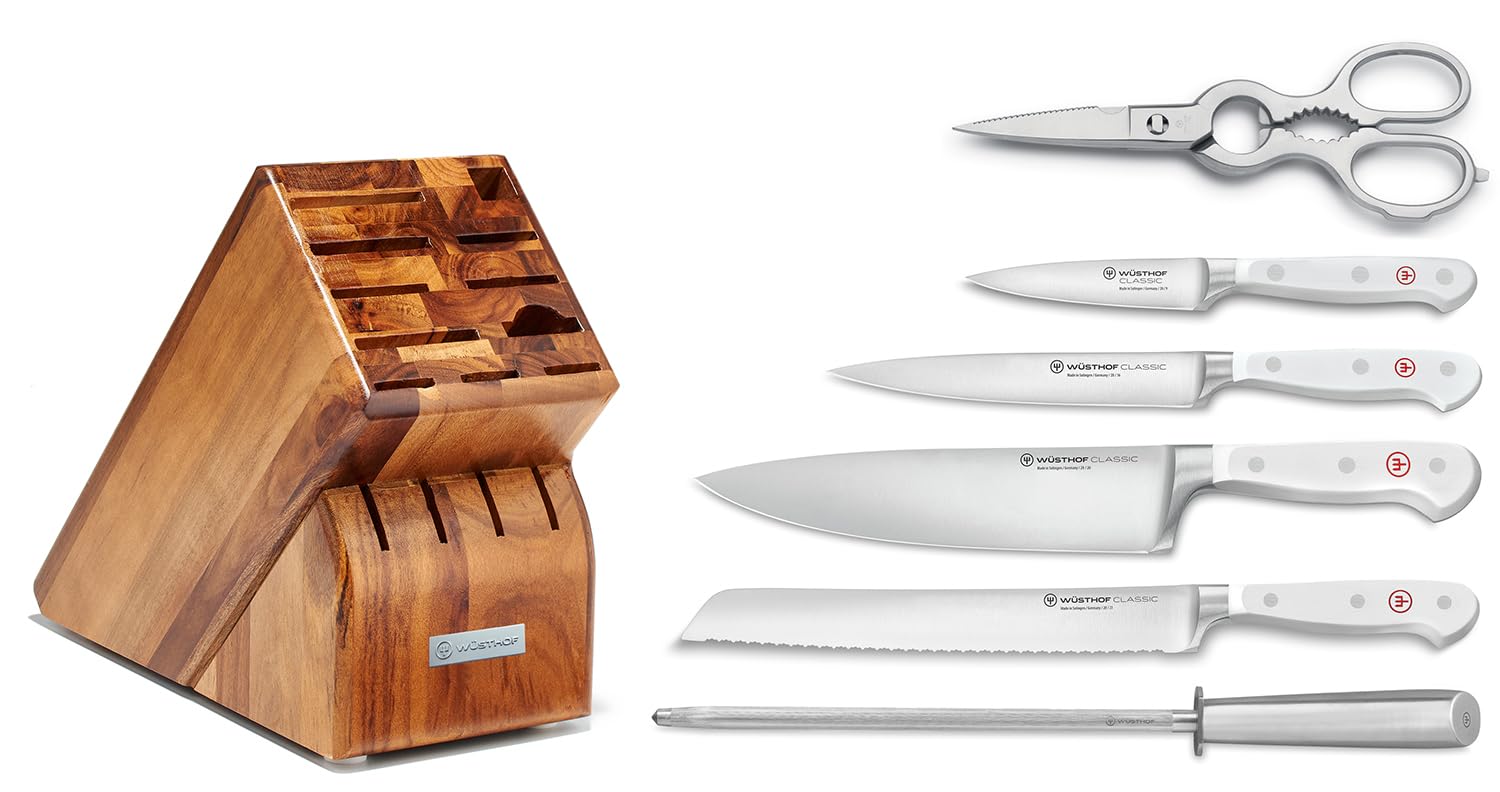 Wooden knife block with knives and a set of scissors on a white background
