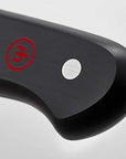 Close-up of a knife handle with a red logo on a gray background