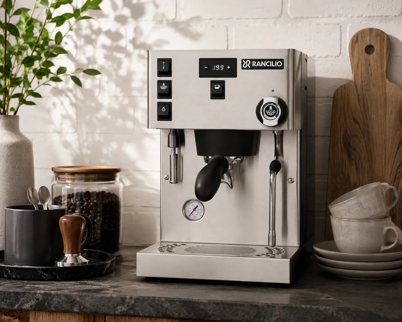 Stainless steel Rancilio coffee machine on a kitchen counter with coffee beans and cups in the background.