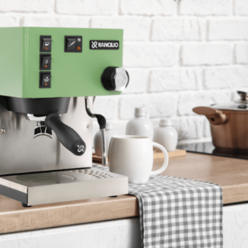 Green Rancilio coffee machine on a kitchen counter with a white brick wall background