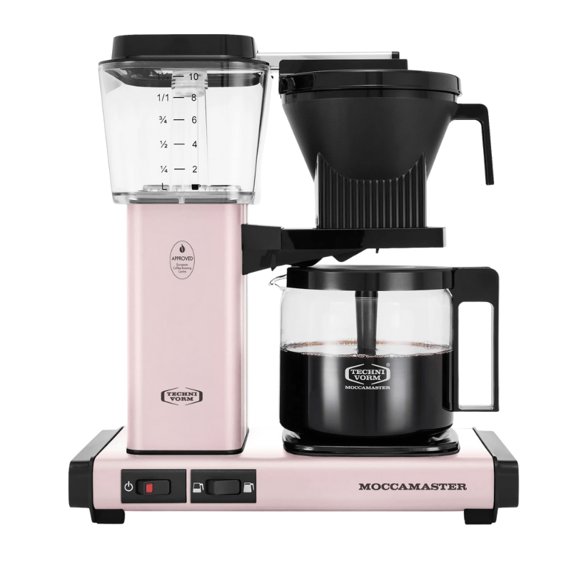 Pink Moccamaster coffee maker with clear carafe on a white background
