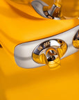Close-up of a yellow appliance with metallic control panel on a yellow background