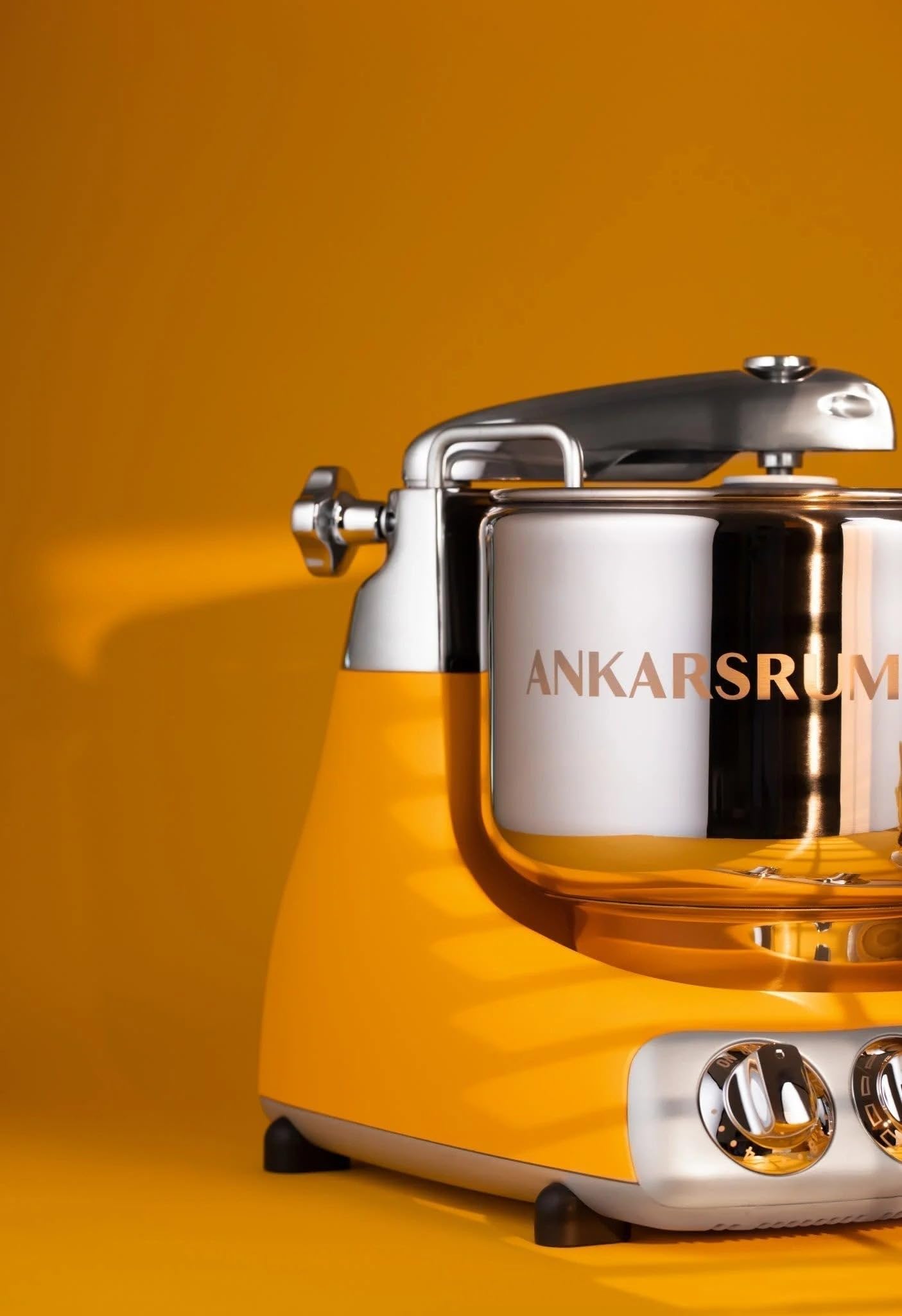 Yellow kitchen stand mixer with 'Ankarsrum' branding on a yellow background