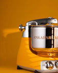 Yellow kitchen stand mixer with 'Ankarsrum' branding on a yellow background