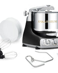 A black kitchen stand mixer with various attachments on a white background