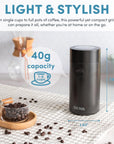 Coffee grinder with coffee beans on a kitchen counter, featuring the brand 'Aroma'.