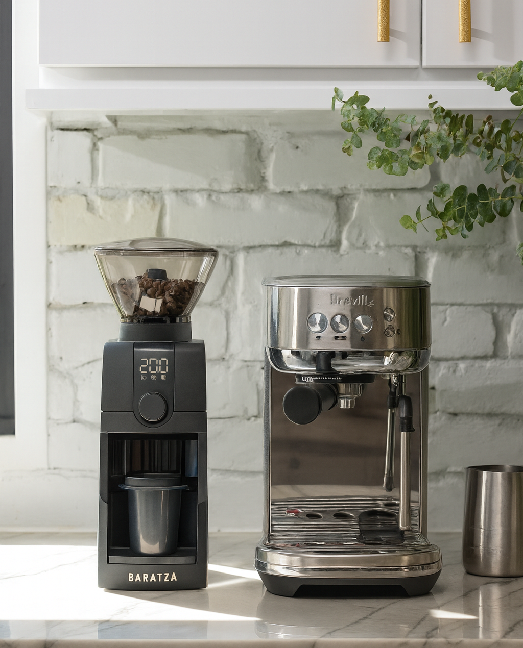 Coffee grinder and espresso machine on a kitchen counter with a white brick wall background.