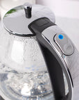 Close up of blue indicator button on a black and polished chrome Capresso 48 oz electric kettle displayed on a white background