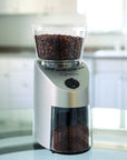Capresso coffee grinder with coffee beans on a blurred kitchen background